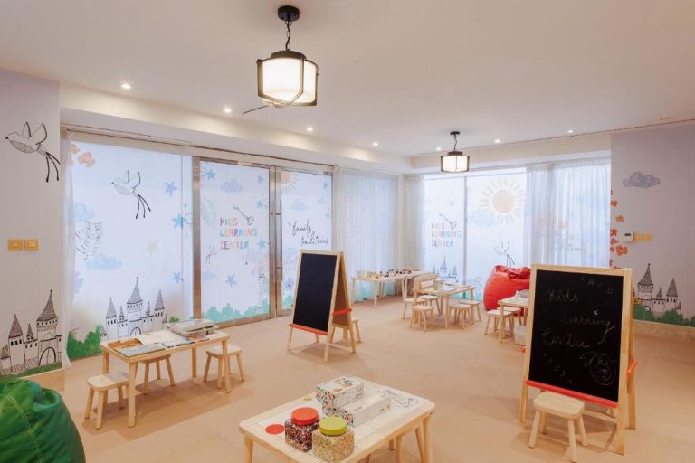 Sala de juegos y aprendizaje para niños en The St. Regis Doha con pizarras y mesas infantiles