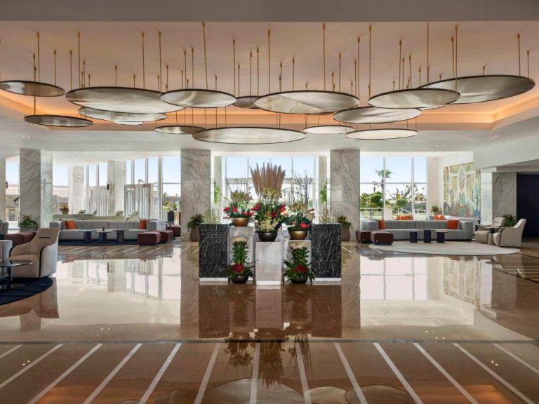 Lujoso lobby con recepción de mármol y arreglos florales en Pickalbatros Golf Luxury Suites All Inclusive