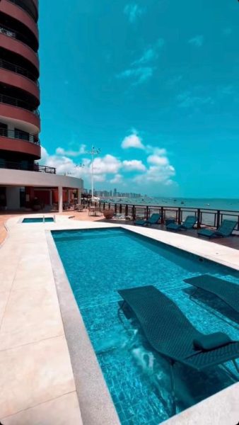 Piscina exterior con tumbonas y vista al mar del Iate Plaza Flat 613 en Brasil