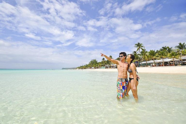 Pareja disfrutando de la playa de aguas cristalinas en Paradise Garden Hotel Boracay by ASTON