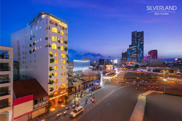 Vista nocturna de la fachada exterior del Silverland Bến Thành con el skyline de Ho Chi Minh City