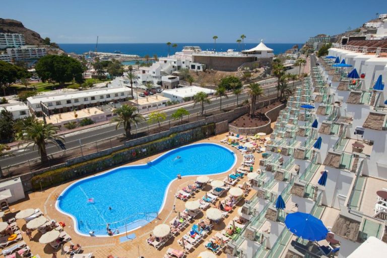 Piscina exterior con tumbonas y sombrillas del Grupotel Revoli con vistas al mar en Gran Canaria