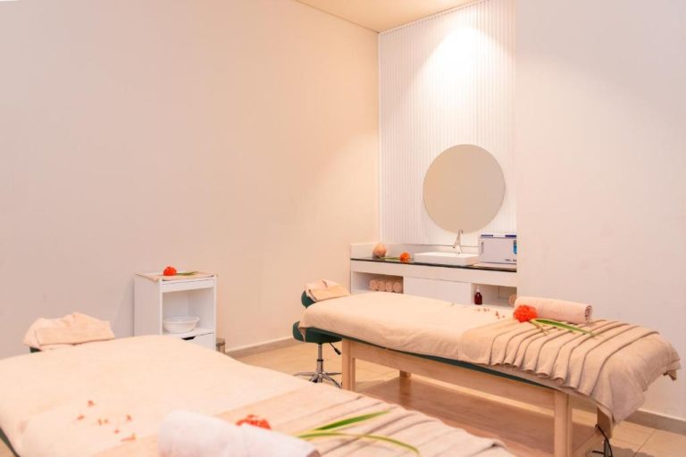 Sala de masajes doble con camillas y decoración floral del Royal Green Wellness Resort