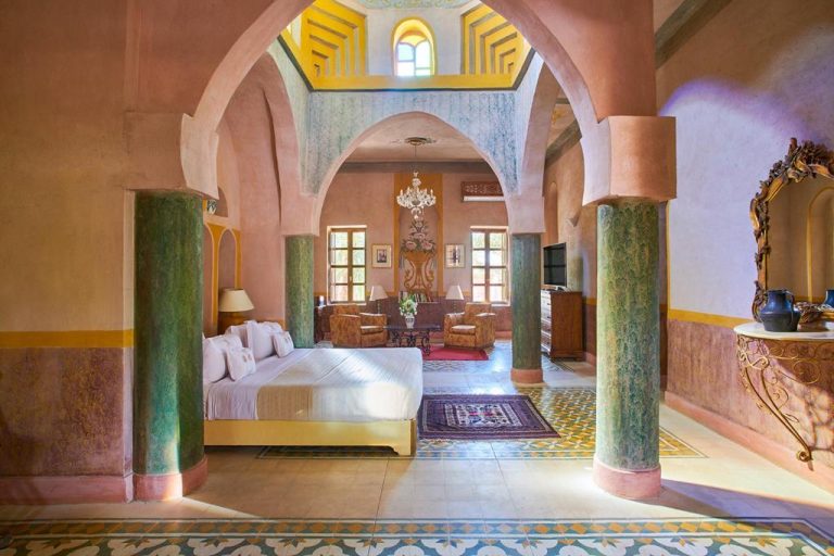 Lujosa suite con arcos árabes, columnas verdes y cama doble en el Al Moudira Hotel de Luxor