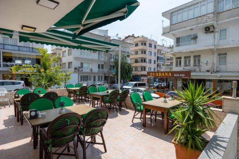 Terraza exterior con mesas y sillas del Hikmethan Otel con vistas a la ciudad de Adana