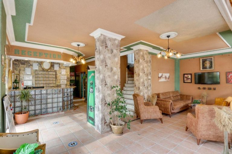 Recepción y zona de lobby con sofás del Hikmethan Otel, decoración clásica con columnas y iluminación cálida