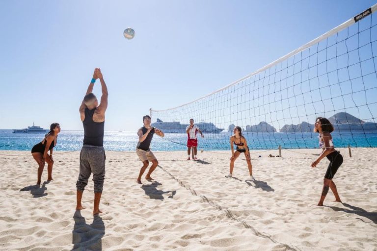 Grupo de huéspedes jugando voleibol en la playa del Hotel Riu Santa Fe All Inclusive en Los Cabos