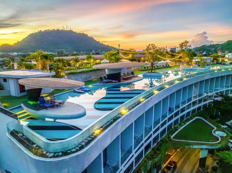 Piscina infinity en la azotea del HOMA Phuket Town con vistas panorámicas al atardecer y montañas