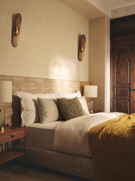 Habitación doble con decoración árabe y ropa de cama dorada en el hotel IZZA Marrakech