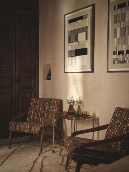 Salón íntimo con sillones vintage y mesa auxiliar dorada en el hotel IZZA Marrakech