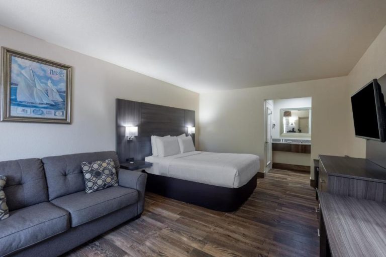 Habitación con cama doble y sofá en Travelodge by Wyndham Florida City Homestead Everglades