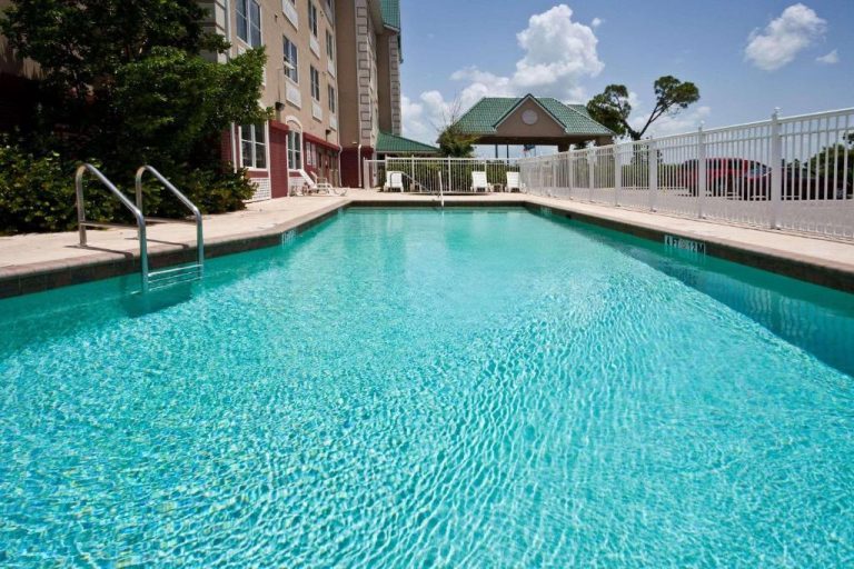 Piscina exterior con agua turquesa del Country Inn & Suites by Radisson en Port Charlotte, Florida