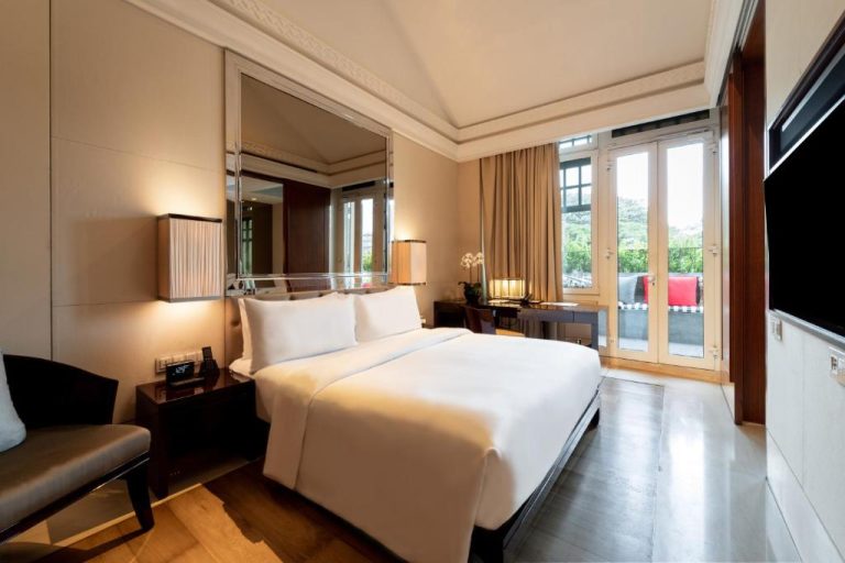 Habitación deluxe con cama king size y balcón en The Capitol Kempinski Hotel Singapore