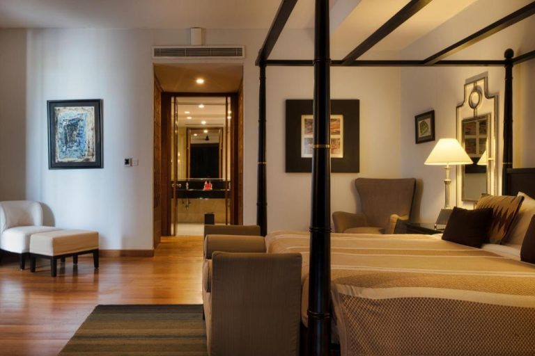 Suite de lujo con cama de dosel y sala de estar en The Blue Water Geoffrey Bawa Heritage Resort