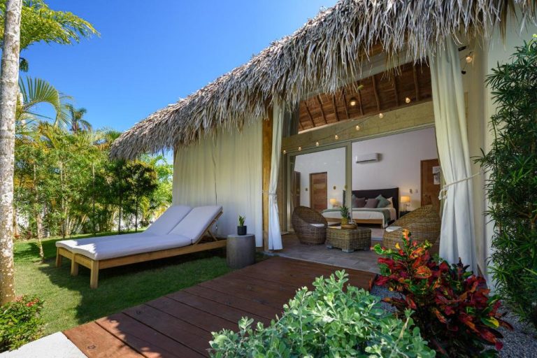 Villa con terraza de madera, tumbonas y jardín tropical en Takuma Boutik Hotel