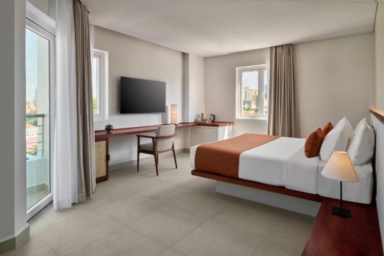 Habitación deluxe con cama doble, escritorio y balcón en Plantation Urban Resort & Spa