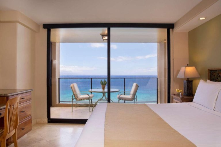 Habitación con cama doble y balcón con vistas al mar turquesa en Aston Mahana at Kaanapali