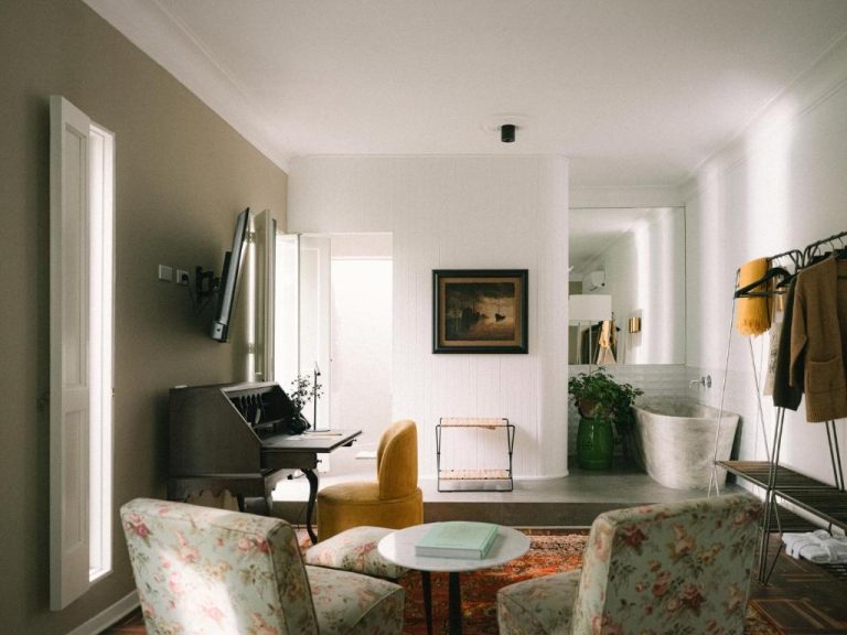 Suite con bañera exenta, sillones florales y escritorio vintage en el hotel Fausto by Andean
