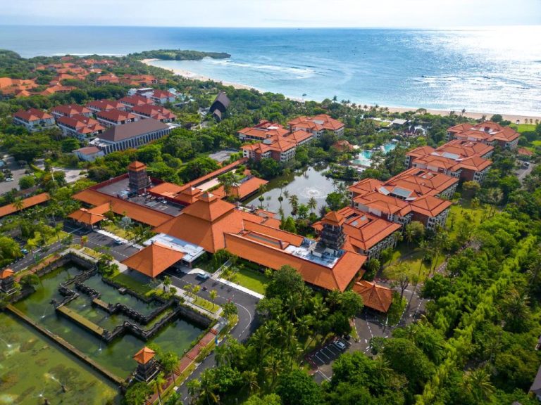 Vista aérea del Ayodya Resort Bali con edificios de tejados rojos, jardines tropicales y playa
