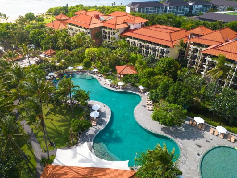 Vista aérea de la piscina laguna tropical del Ayodya Resort Bali rodeada de jardines y palmeras