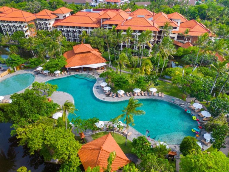 Vista aérea de la piscina laguna tropical del Ayodya Resort Bali rodeada de palmeras y jardines