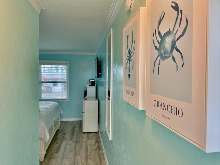 Habitación con decoración marina y cuadros de cangrejo y langosta en el Flamingo Inn