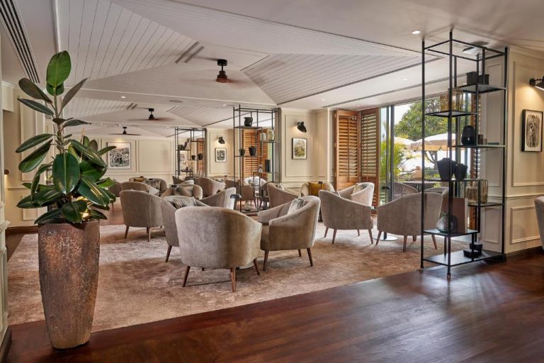 Elegante salón lounge con sillones tapizados y grandes ventanales en The Cliff Bay PortoBay