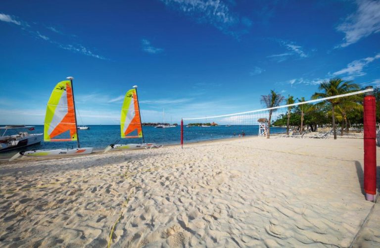 Playa con red de voleibol y catamaranes en el Hotel Riu Montego Bay Adults Only All Inclusive Jamaica