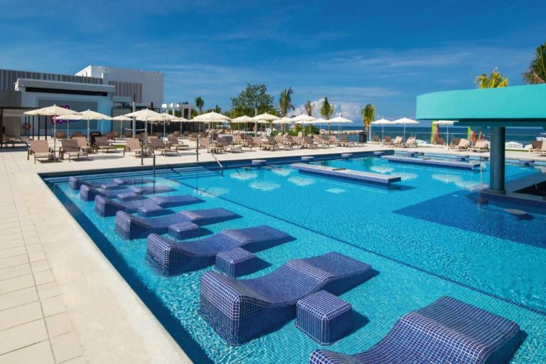 Piscina exterior con tumbonas acuáticas azules y zona de hamacas en Riu Montego Bay Adults Only