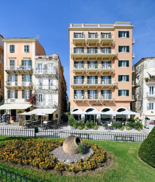 Fachada exterior del Arcadion Hotel en Corfú con jardines florales y terraza de restaurante