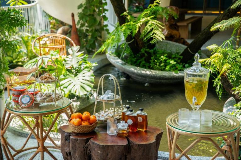 Mesa de bienvenida con frutas, miel y bebidas en el jardín tropical del Saha Casa Boutique Hotel Da Nang