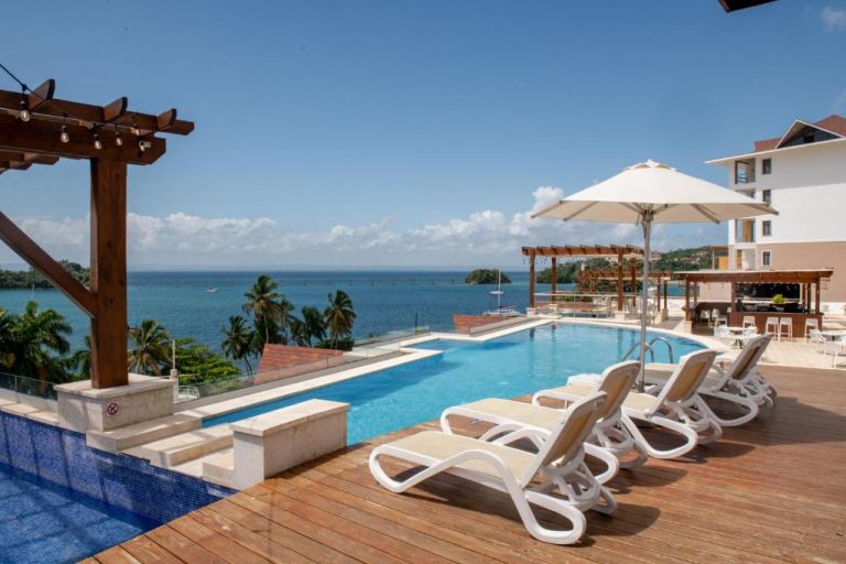 Piscina exterior con tumbonas y vista al mar en el Hacienda Samana Bay Hotel, República Dominicana