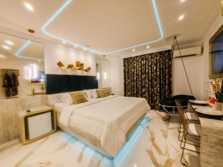 Habitación de lujo con cama king, suelo de mármol e iluminación LED azul en Glória Plaza Hotel Adults Only