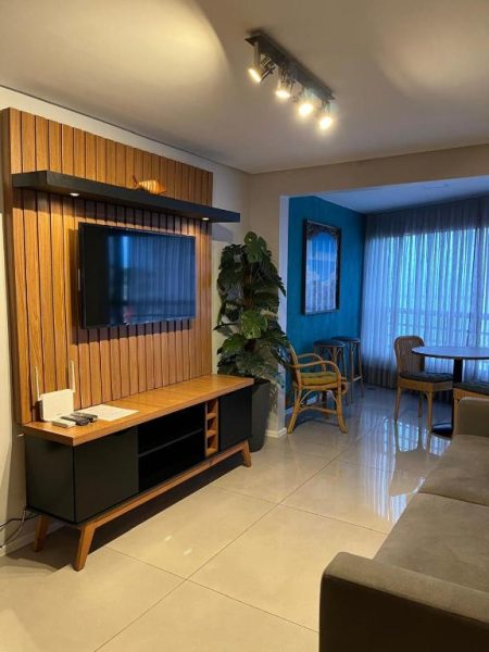 Sala de estar moderna con panel de madera y televisor del Iate Plaza Flat 613