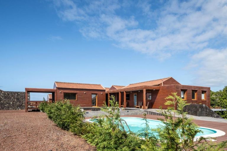 Piscina exterior con casa de madera y jardín en Alma do Pico Nature Residence en las Azores