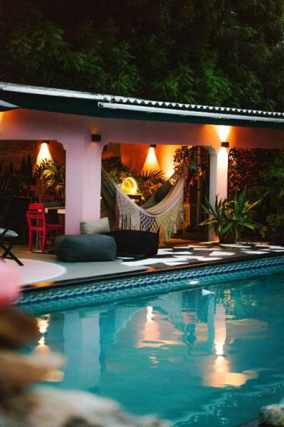 Piscina iluminada de noche con hamaca y zona lounge en Thuishaven Boutique Mini-Resort