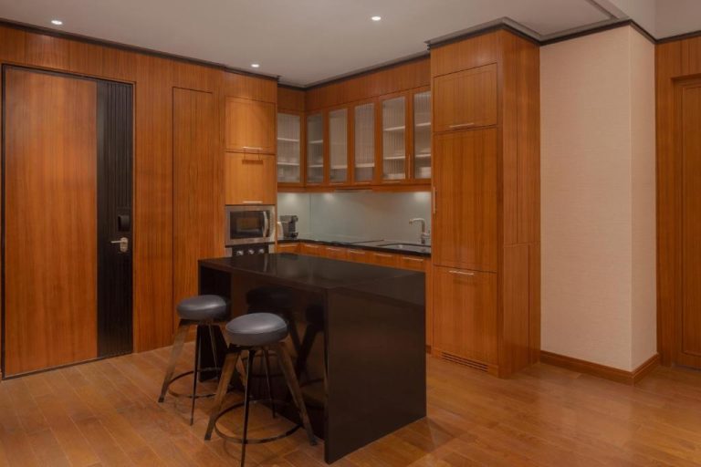 Cocina equipada con isla central y gabinetes de madera en ITC Ratnadipa Luxury Collection Hotel Colombo