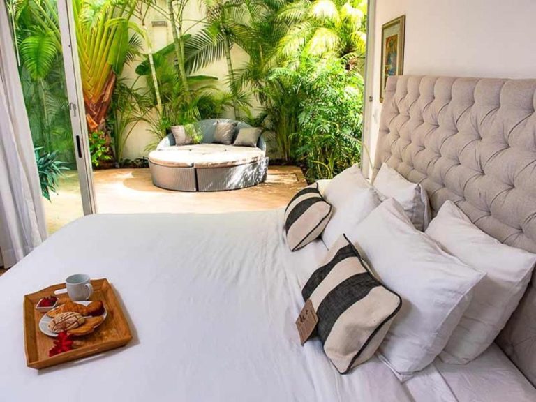 Habitación de lujo con desayuno en cama y jardín tropical privado en Magia Beachside Condo