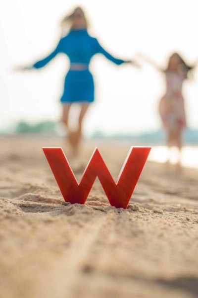 Logo del W Doha en la arena de la playa con ambiente de lujo y diversión junto al mar