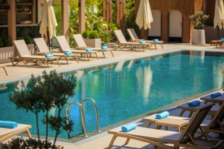 Piscina exterior con tumbonas y sombrillas del Casa Lumar Luxury Lodging Adult Only