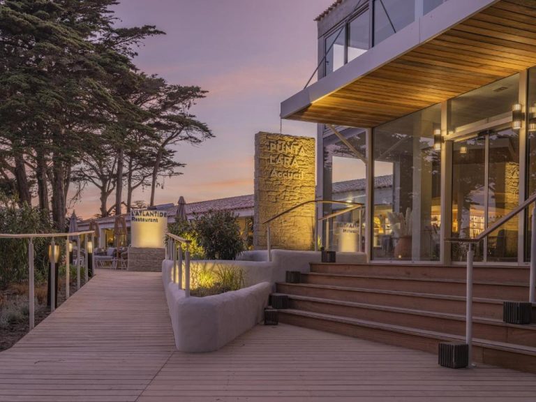 Terraza de madera y entrada principal del Hotel Punta Lara Noirmoutier al atardecer con restaurante L'Aylantide