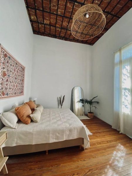 Habitación doble con techo de ladrillo visto y suelo de madera en Casa Rebelión