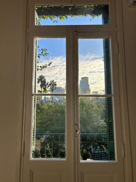 Ventana francesa con vistas a árboles y edificios desde habitación de Casa Rebelión Buenos Aires