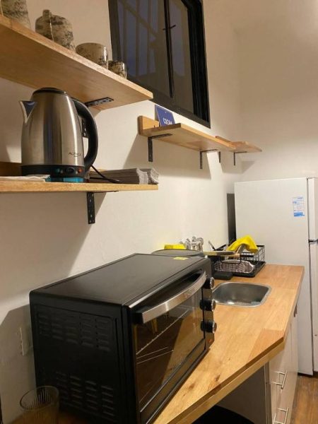 Cocina equipada con microondas, hervidor eléctrico y fregadero en Casa Rebelión