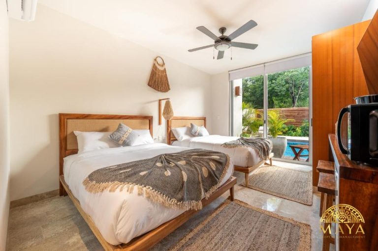 Habitación doble con dos camas y acceso a piscina exterior en Nhoa Tulum Aparthotel by Maya PM
