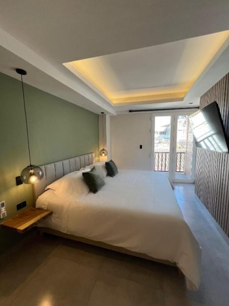 Habitación doble moderna con cama king size y balcón en De la Cruz Studio Apartments