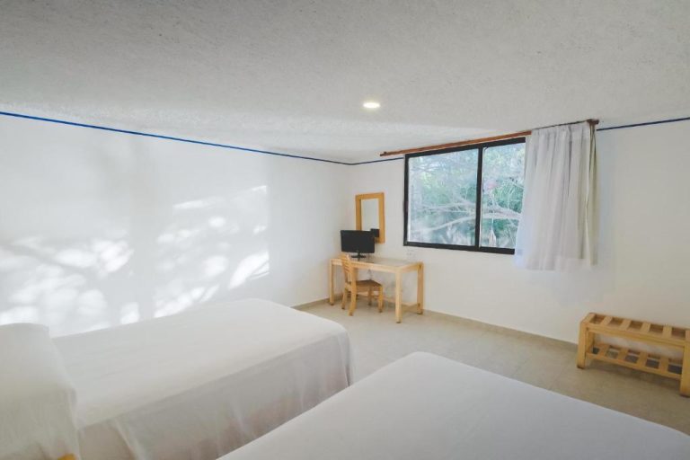 Habitación doble con dos camas y escritorio en Sotavento Hotel & Yacht Club con vistas al jardín
