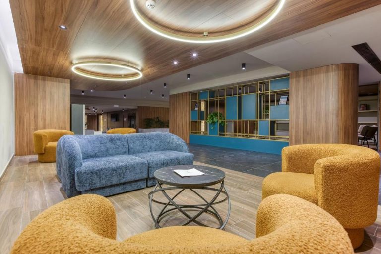 Elegante lobby del Solana Hotel & Spa con sofás azules y sillones amarillos en zona de recepción