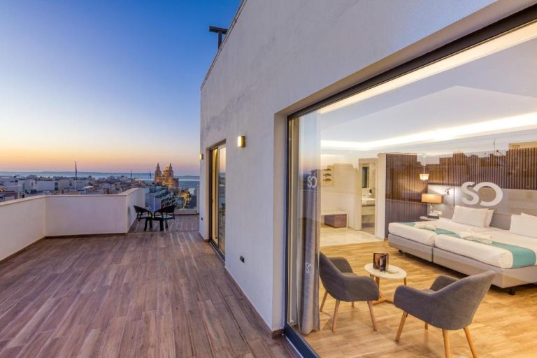 Suite con terraza privada y vistas panorámicas de la ciudad al atardecer en Solana Hotel & Spa