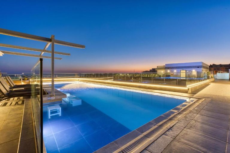 Piscina exterior en la azotea del Solana Hotel & Spa iluminada al atardecer con vistas panorámicas
